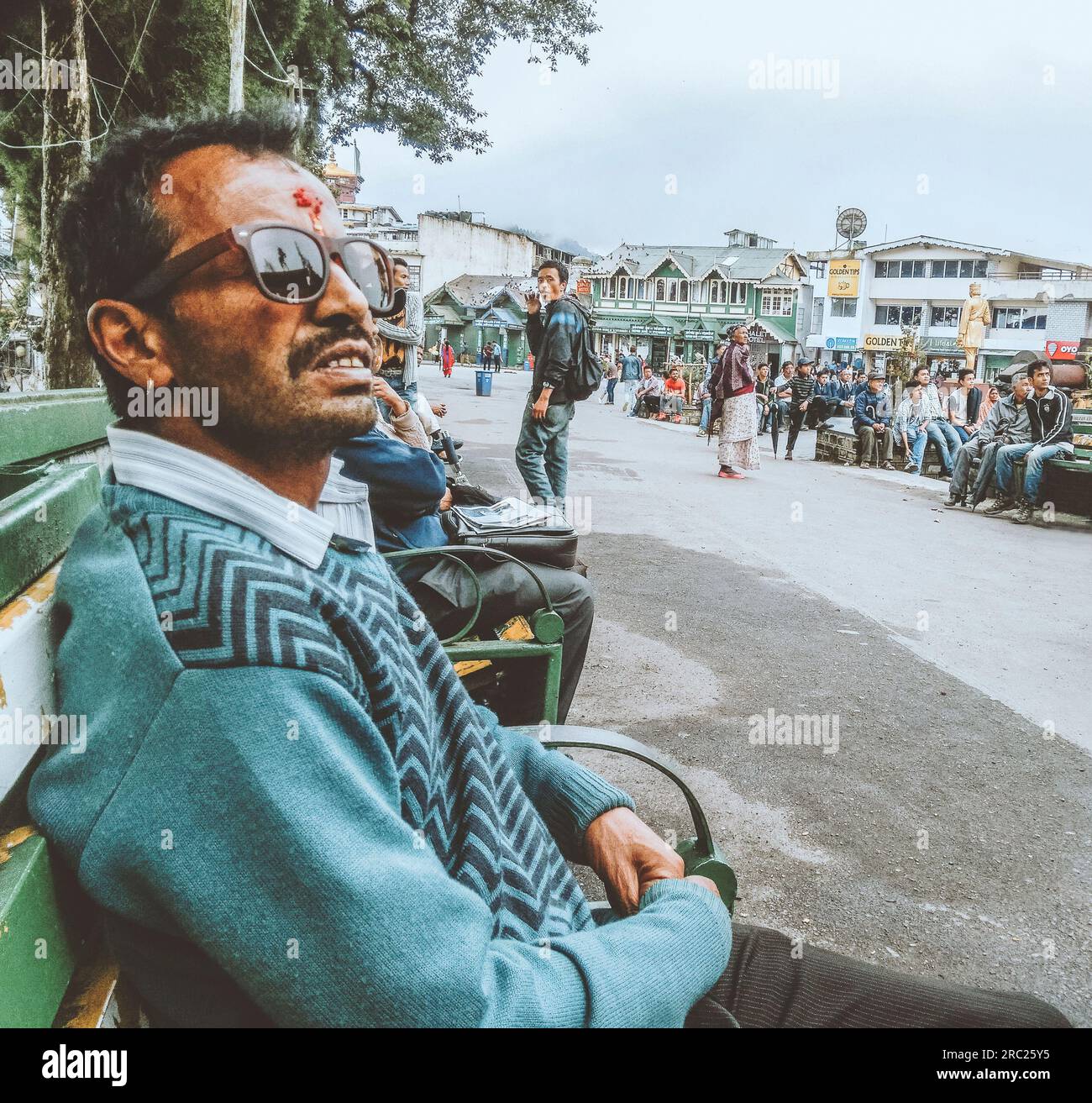 A man wearing sunglasses looking at big screen at Darjeeling City Centre, India. Stock Photo