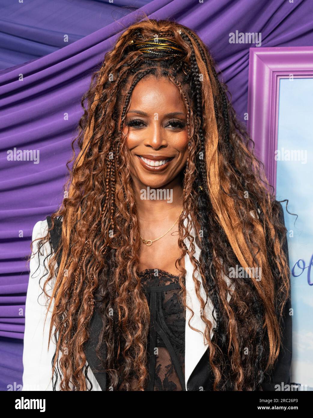 Tasha Smith wearing dress by Dolce and Gabbana attends New York