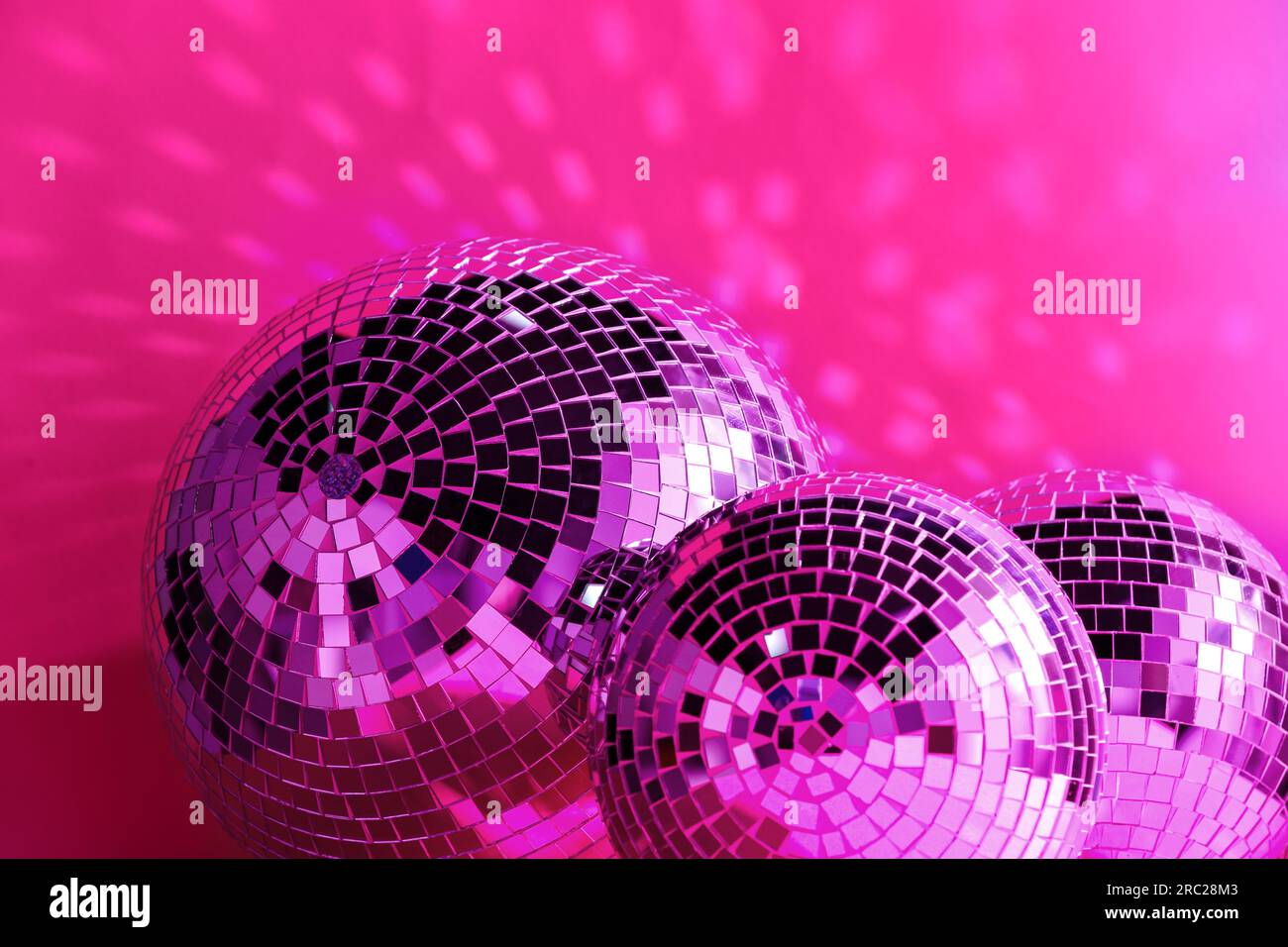Many shiny disco balls near color wall, toned in pink Stock Photo Alamy