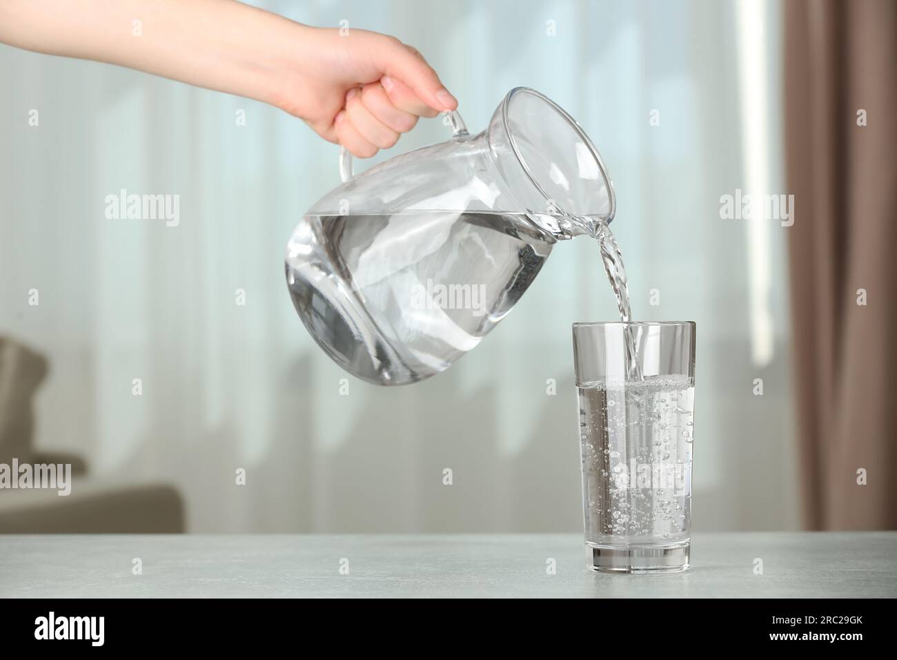 Pour water from a pitcher into a glass Stock Photo - Alamy