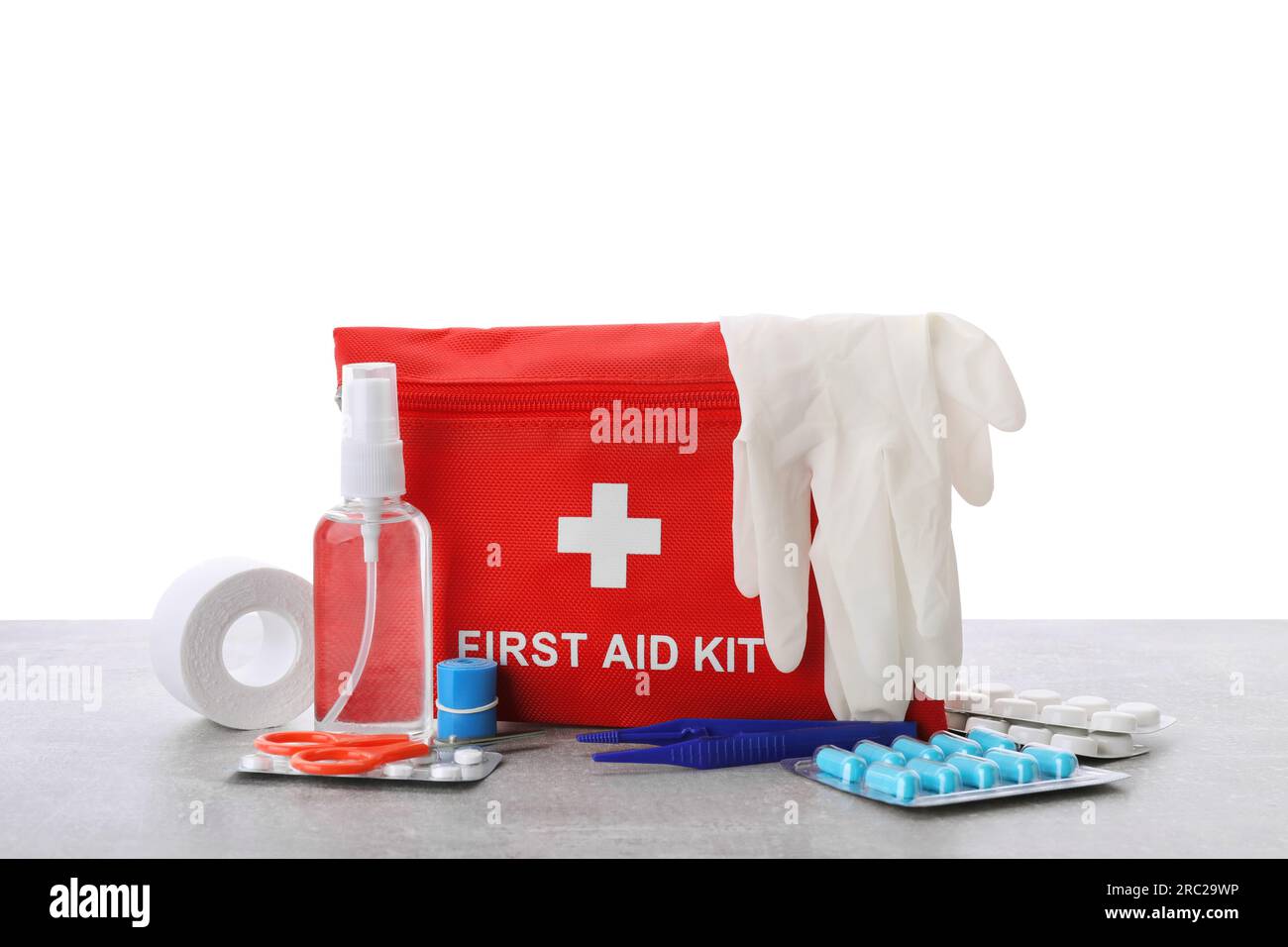 First Aid Kit Scissors Gloves Pills Plastic Forceps And Elastic Bandage On Light Grey Table 8004