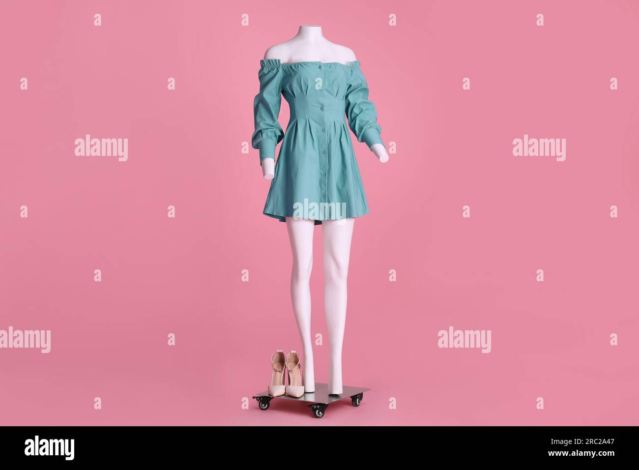 Female mannequin with shoes and necklace dressed in stylish light blue dress  on pink background Stock Photo - Alamy