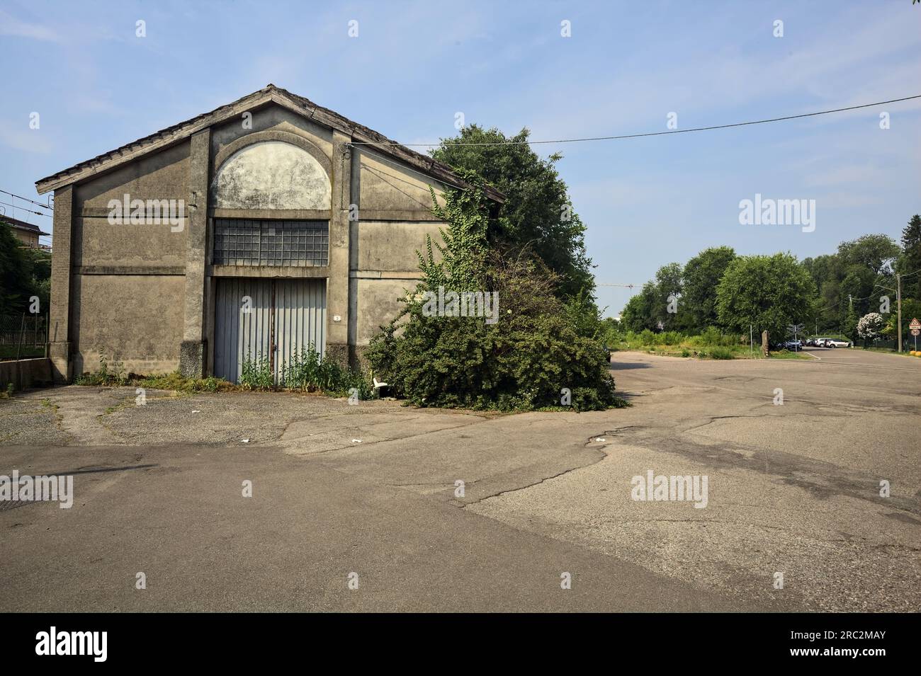 Warehouse and yard in front of it next to railroad tracks on a sunny ...