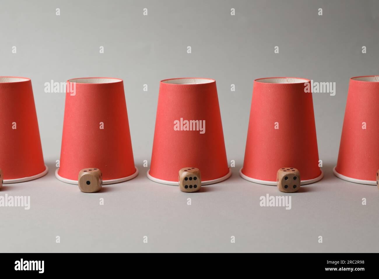 Red cups and dices on light grey background. Thimblerig game Stock ...
