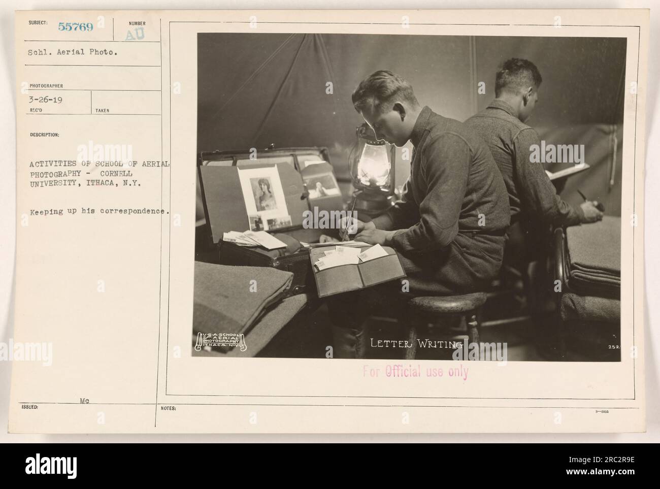 In this image from the Photographs of American Military Activities during World War One, a student at the School of Aerial Photography at Cornell University in Ithaca, N.Y., is seen keeping up with his correspondence. The photo was taken on March 26, 1919, as part of a series documenting the school's activities. The image is labeled as Subject 55769 Schl. Aerial Photo and was taken by Photographer 3-26-19 Reco. The description emphasizes the letter writing activities of the school, with the note that it is for official use only. Stock Photo