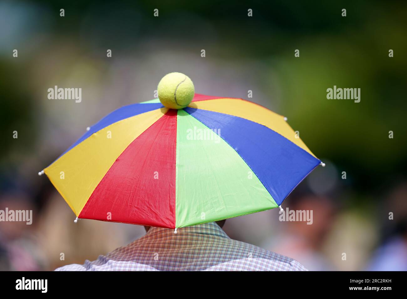 A tennis fan sports an umbrella hat on day nine of the 2023 Wimbledon
