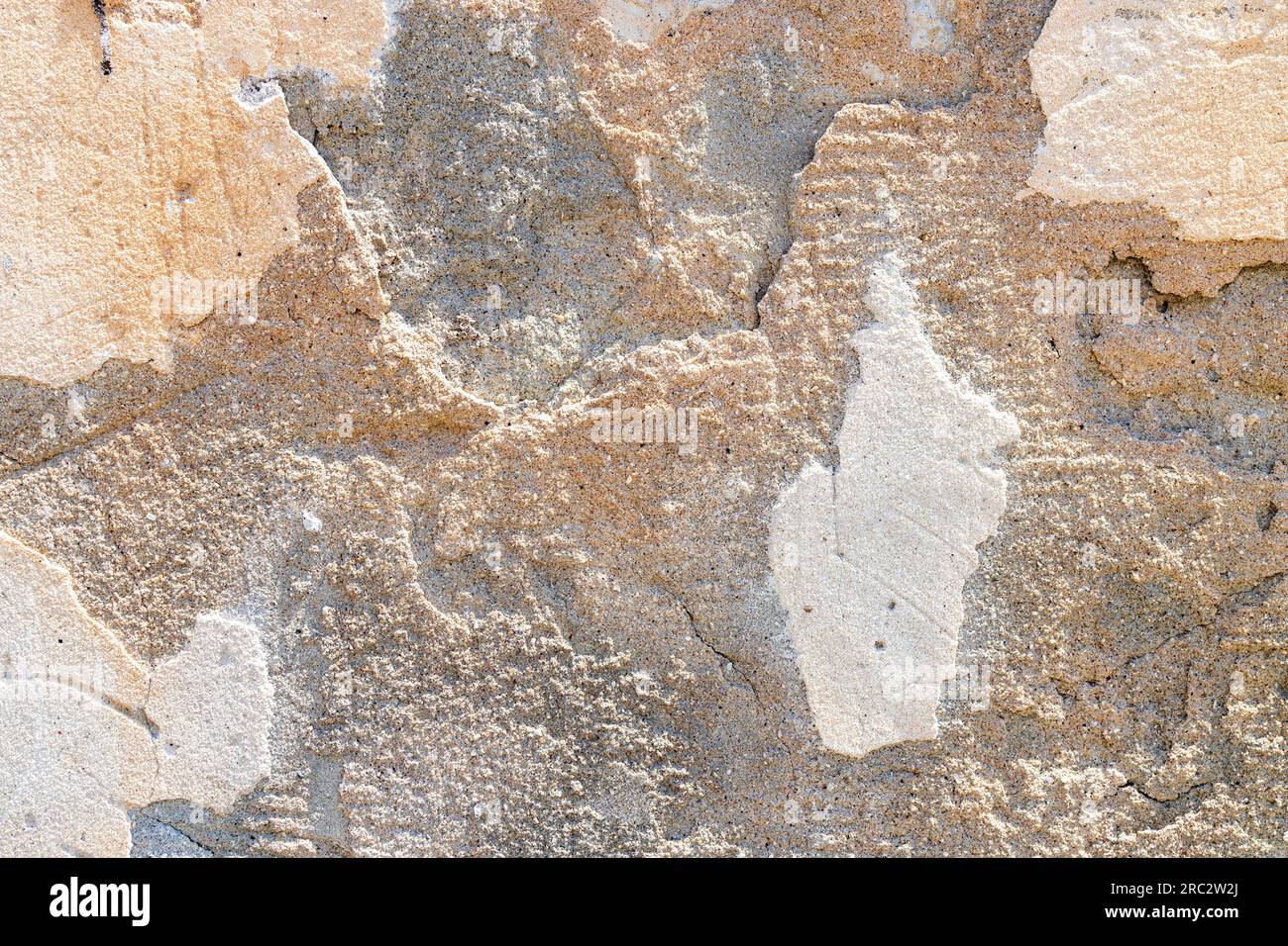 Beige texture of a plastered old abandoned wall with a shadow from the sunlight Stock Photo