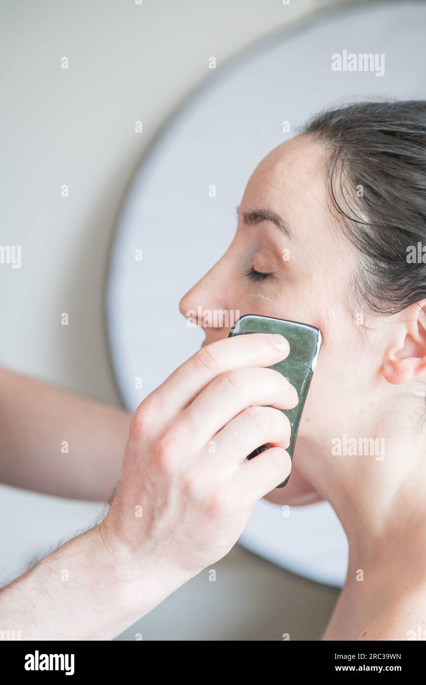 Young Caucasian woman getting facial treatment. Therapist doing skin