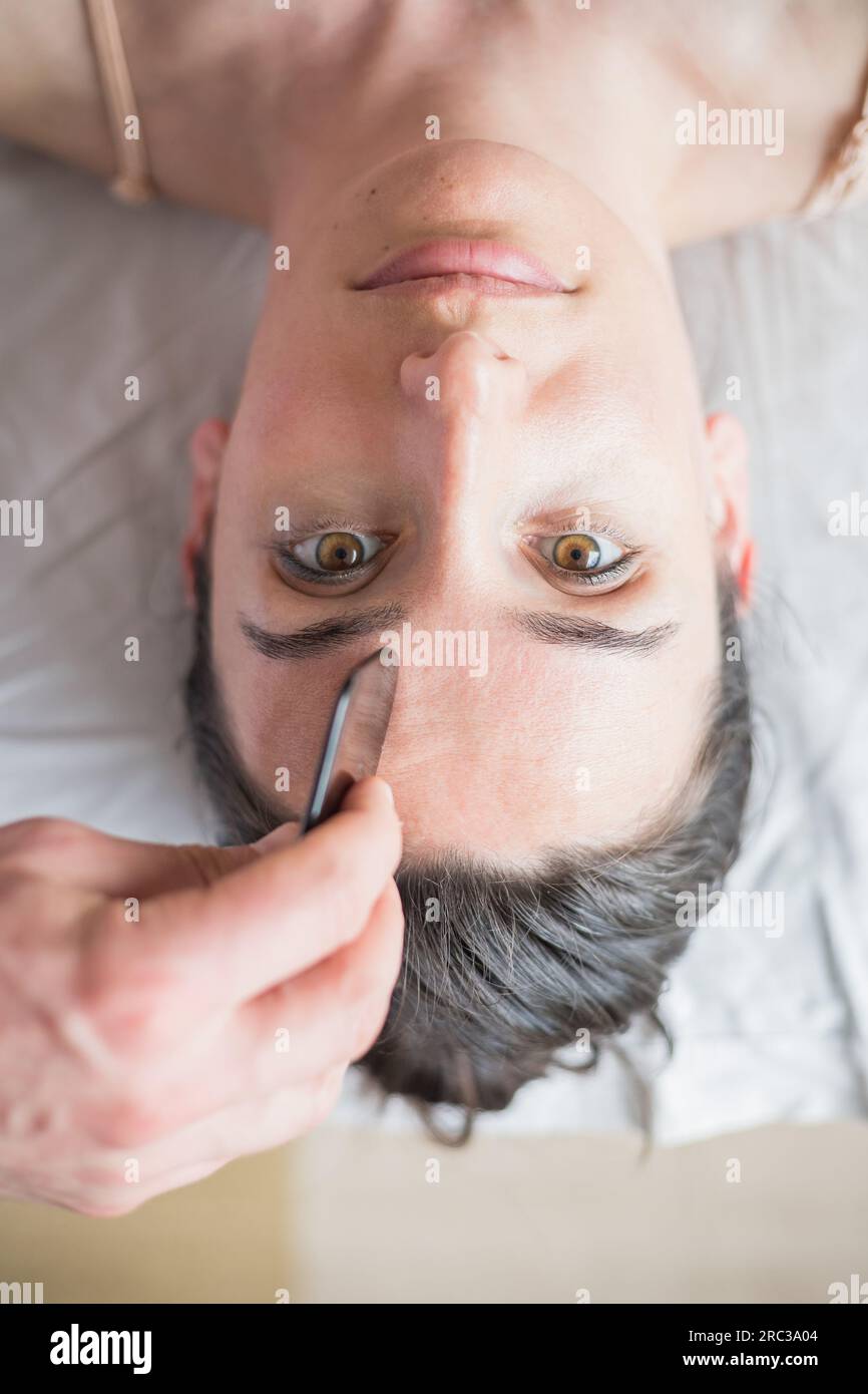 Young Caucasian woman getting facial treatment. Therapist doing skin