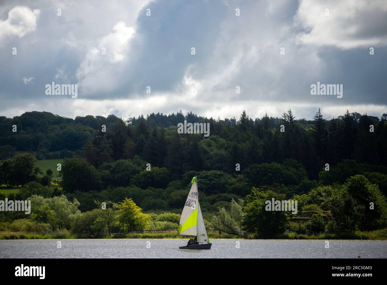 Castle Semple, Lochwinnoch, Scotland, UK. 12th July 2023. Watersport enthusiasts are undeterred by the changeable weather conditions. Castle Semple is used by people of all ages to paddle board and learn sail. Stock Photo