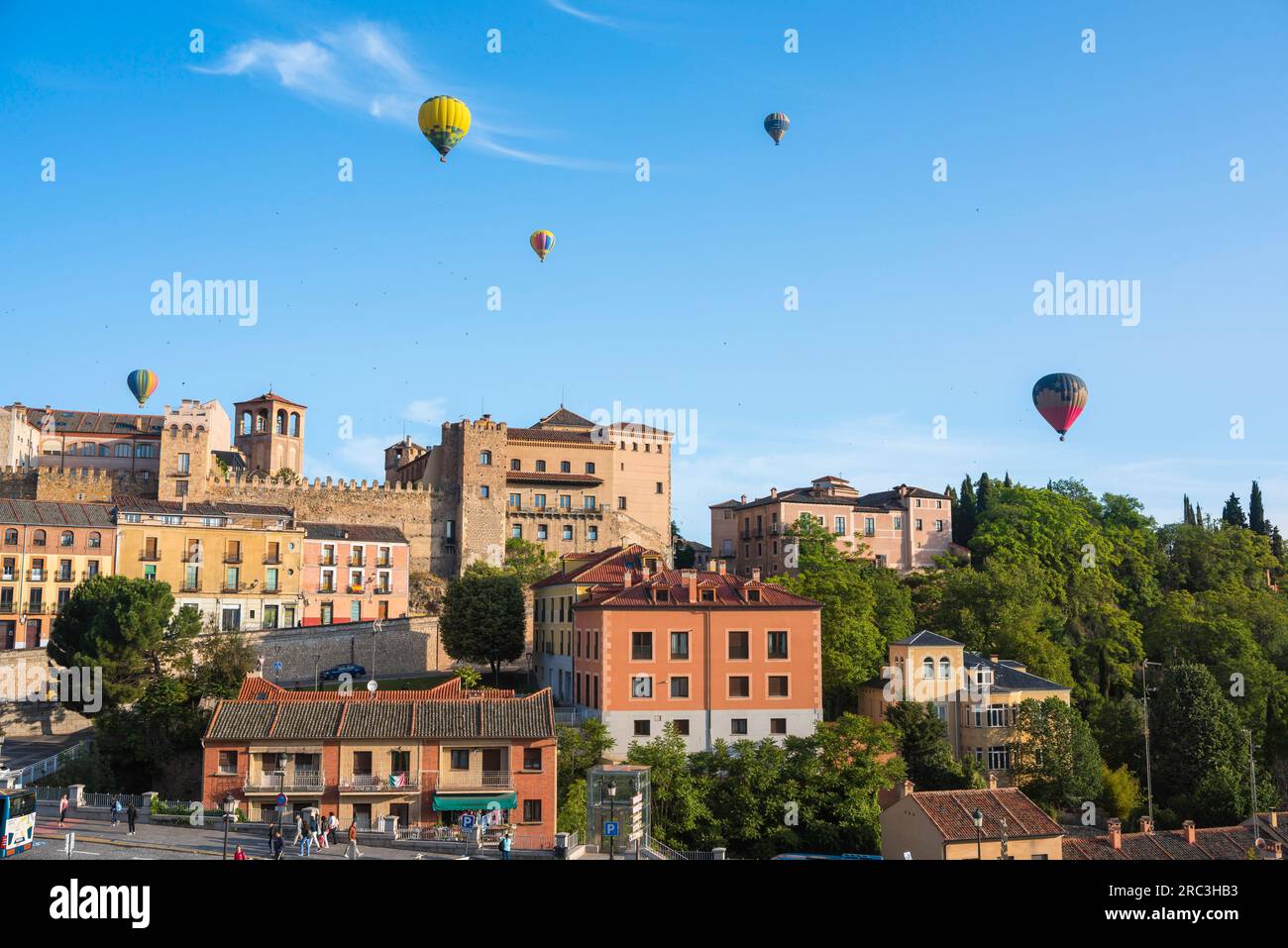Hot air balloon Spain, view in summer of hot air balloons floating over the historic Old Town quarter of the city of Segovia, central Spain Stock Photo