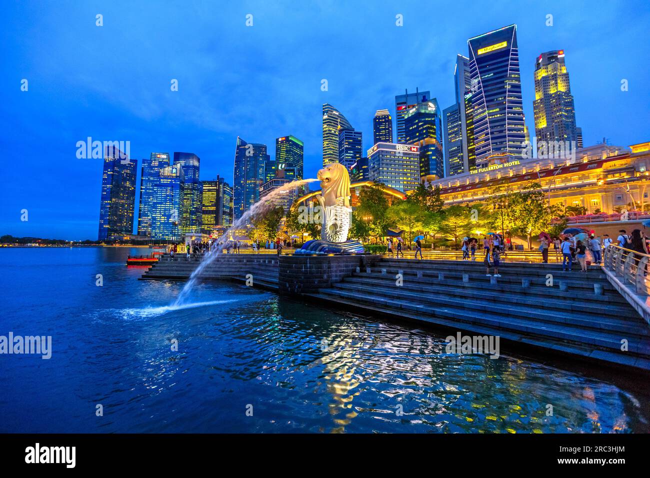 Singapore - April 27, 2018: night scenic Singapore touristic symbol at blue hour, the Merlion Statue in Merlion Park with luminous skyline of CBD Buil Stock Photo