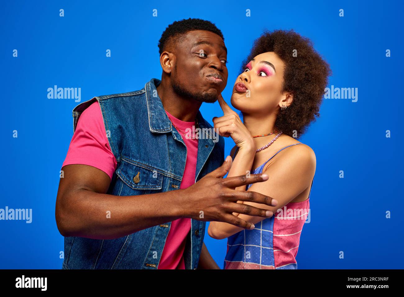 Young african american woman with bold makeup touching cheek of best ...