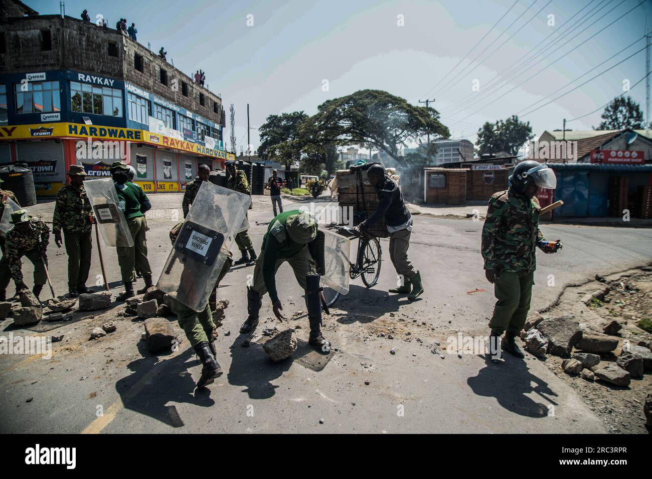 Nakuru, Kenya. 12th July, 2023. Anti-riot police remove boulders and burning tires barricading a road during the protest against the government and high cost of living called by Kenyaís opposition leader Raila Odinga. (Photo by James Wakibia/SOPA Images/Sipa USA) Credit: Sipa USA/Alamy Live News Stock Photo