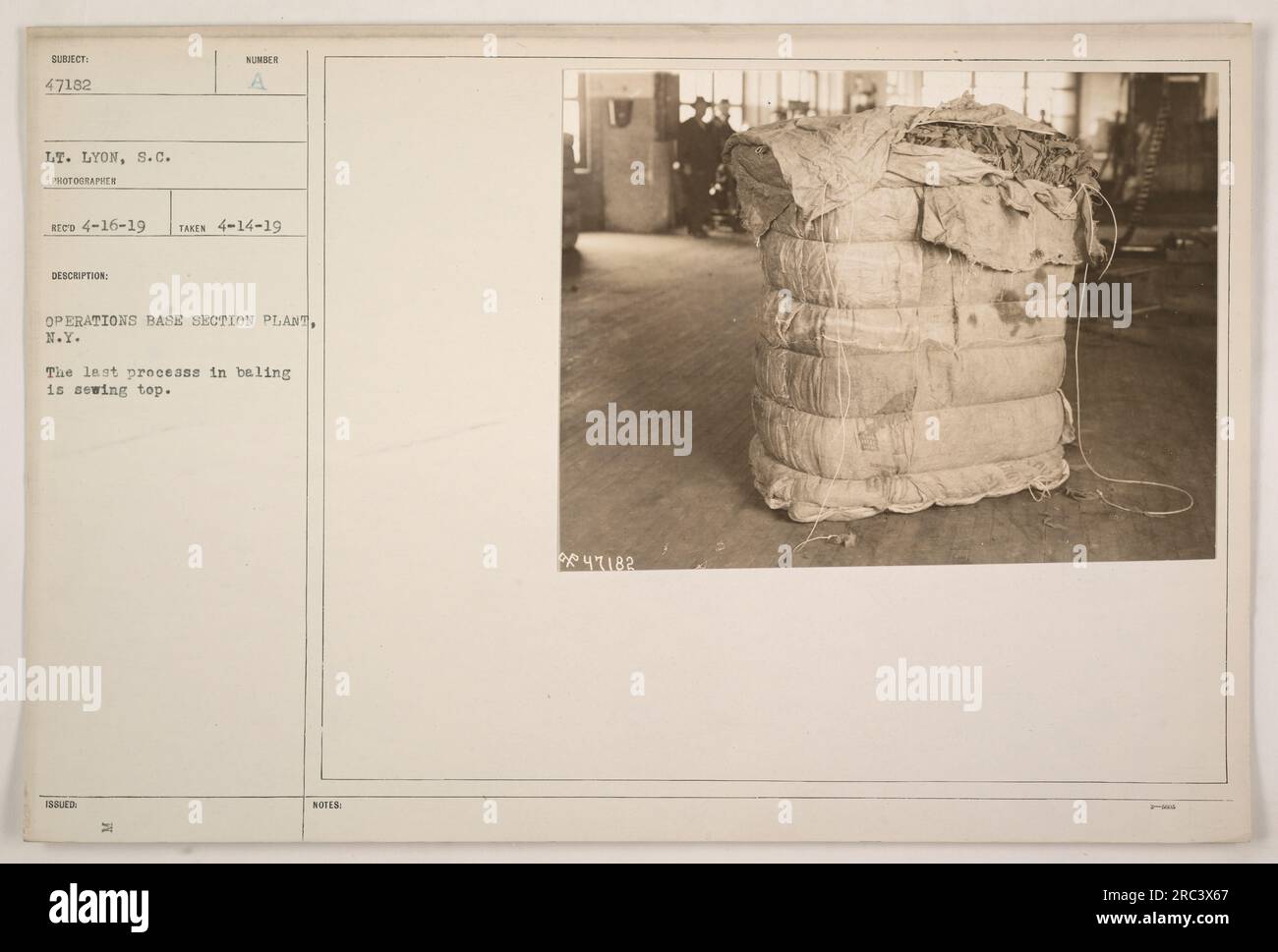 Baling process at Operations Base Section Plant in New York. The final step involves sewing the top of the bale. The photograph was taken on April 14, 1919 by Lt. Lyon, S.C. The image is assigned the number 47182 and was released with issued notes. Stock Photo