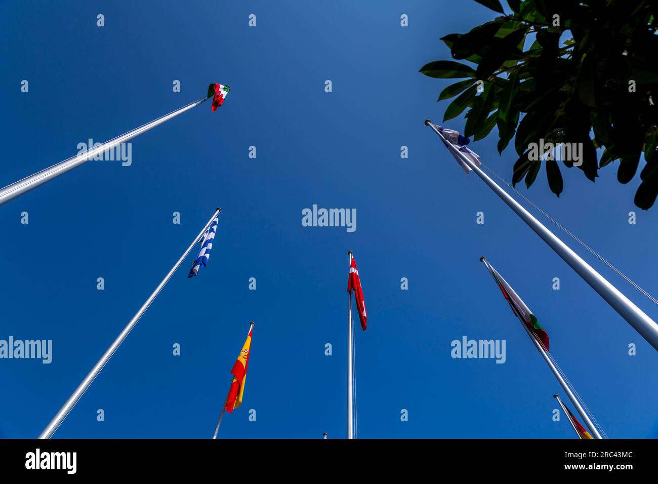 Some European flags waving in the blue sky, international flags Stock Photo
