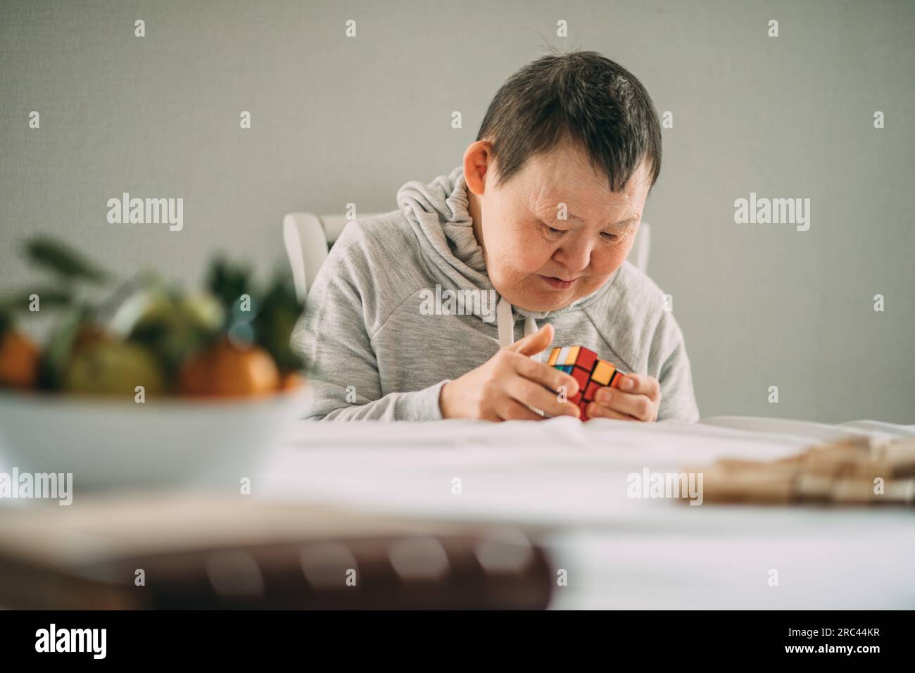 Combining Empathy and Fun: The Extraordinary Story of an Elderly Woman with Down Syndrome and her Passion for a Wood and Brick Tabletop Game Stock Photo