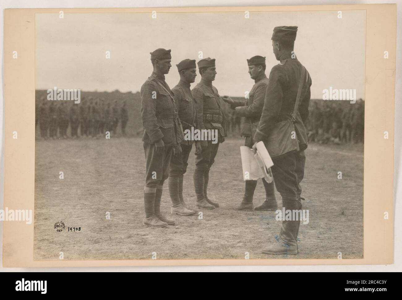 Soldiers gathered around a campfire. They are dressed in military uniforms, indicating their involvement in American military activities during World War I. The image showcases the camaraderie and bonding that occurs between soldiers during times of war. Stock Photo