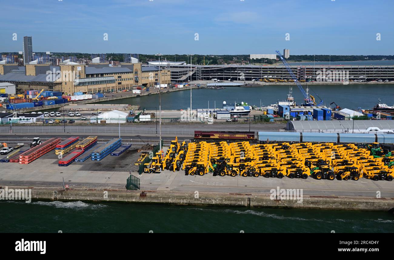 EWS Class 66 diesel-electric freight locomotive No 66083 heading a car carrier train at Southampton docks, with yellow JCB's lined up on the quayside. Stock Photo