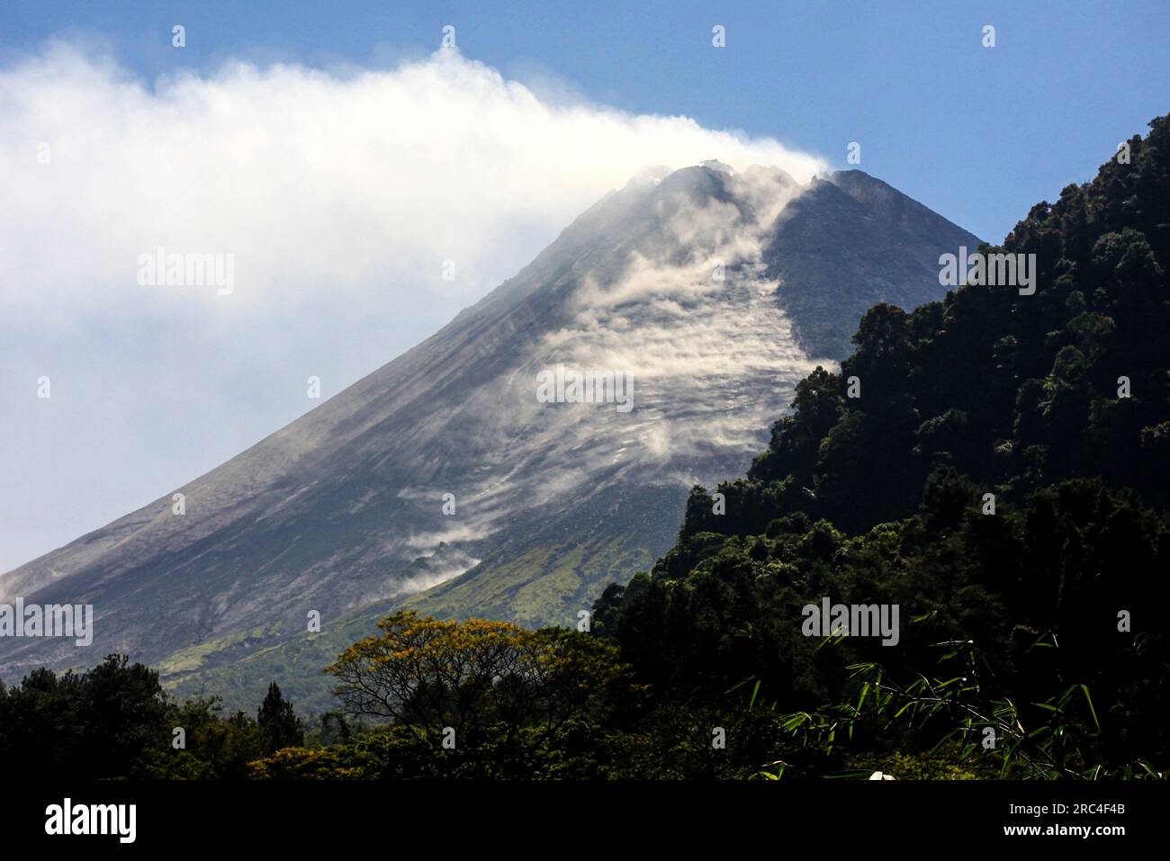 Yogyakarta, Indonesia. 12th July, 2023. Smoke and volcanic materials spew from Mount Merapi as seen from Purwobinangun village in Sleman district, Yogyakarta, Indonesia, July 12, 2023. One of the most active volcanoes in Indonesia, Mount Merapi, erupted 16 times on Wednesday, releasing incandescent lava up to 1,800 m, according to the Center for Volcanology and Geological Hazard Mitigation (PVMBG). Credit: Priyo Utomo/Xinhua/Alamy Live News Stock Photo