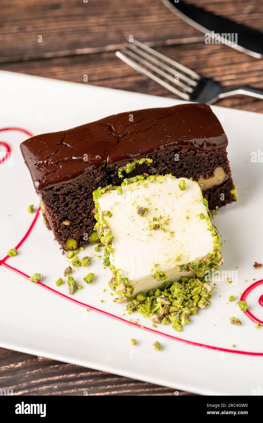 Delicious brownie with vanilla ice cream on a white porcelain plate ...