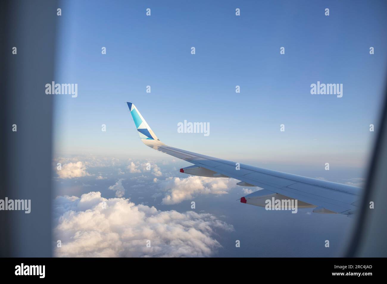 Wing of an airplane flying in the blue sky with white clouds Stock ...