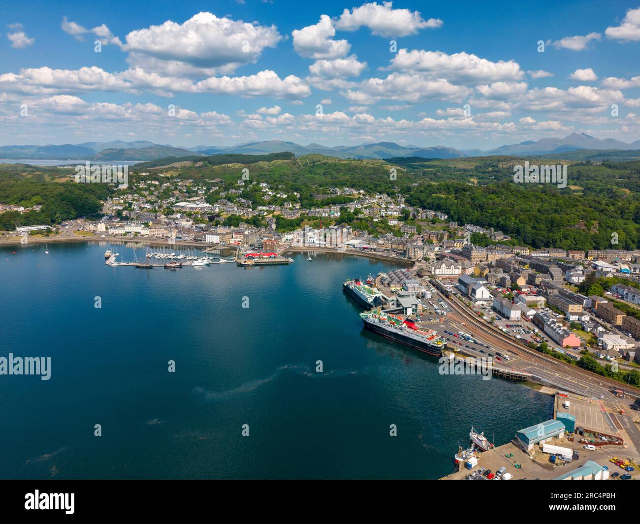 Aerial drone photo of the harbour town Oban in Scotland. It has a large ferry port and an old town centre at the bay. Stock Photo
