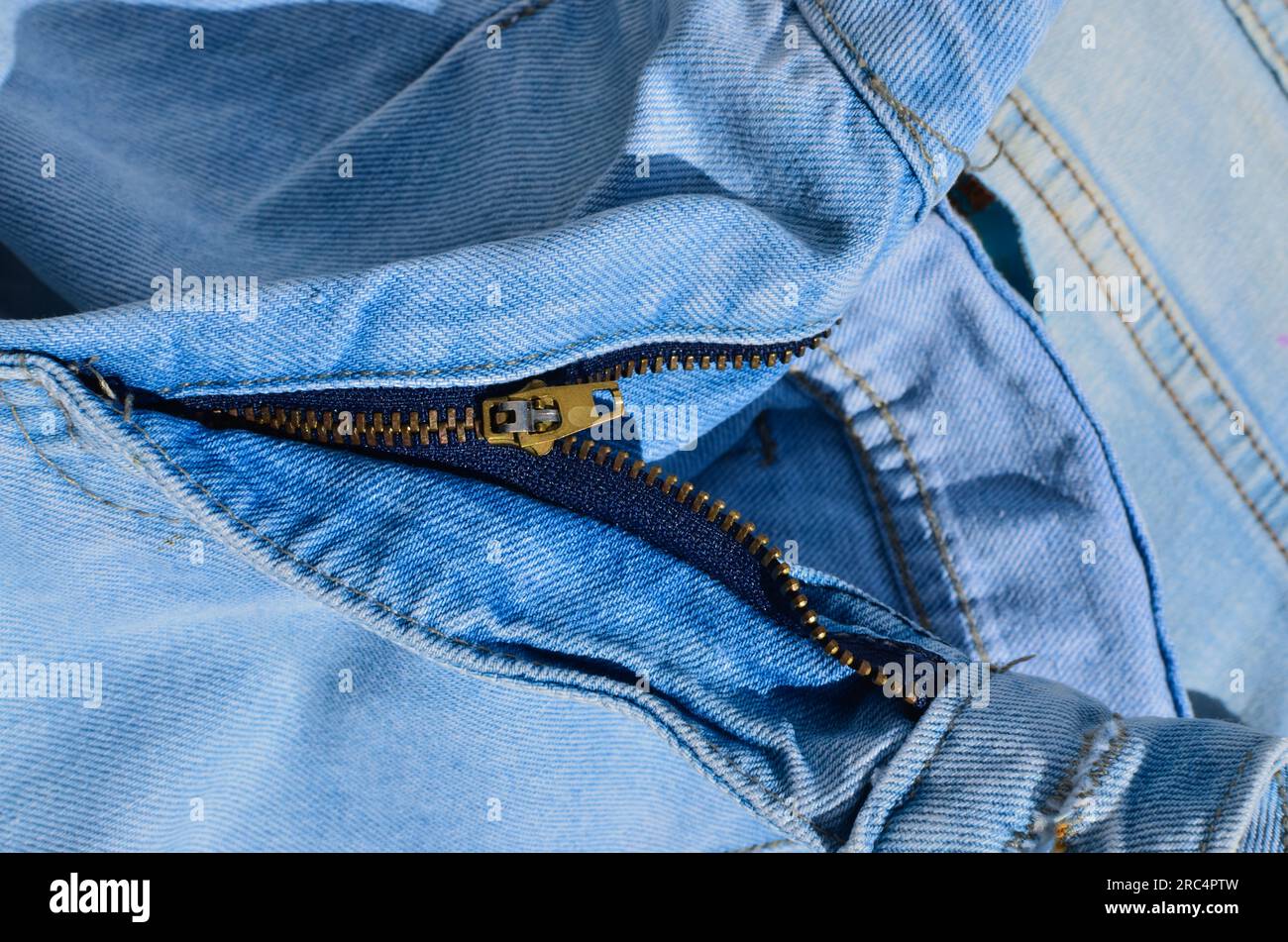 Close-up of jeans stitching, highlighting tough and durable lines. Indispensable for projects related to fashion and clothing. Jeans with zipper. Stock Photo