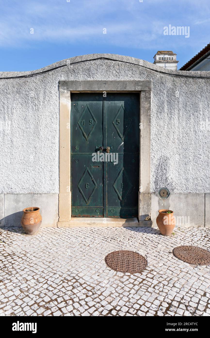 Europe, Portugal, Alentejo Region, Golega, Large Green Entrance Door through wall leading on to Rua Joao de Deus Stock Photo