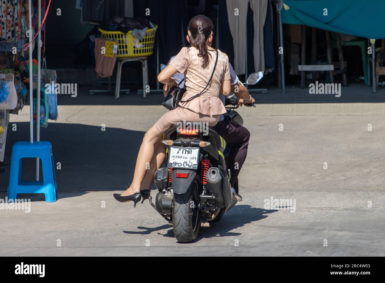 A couple is riding a motorcycle on the street, Thailand Stock Photo