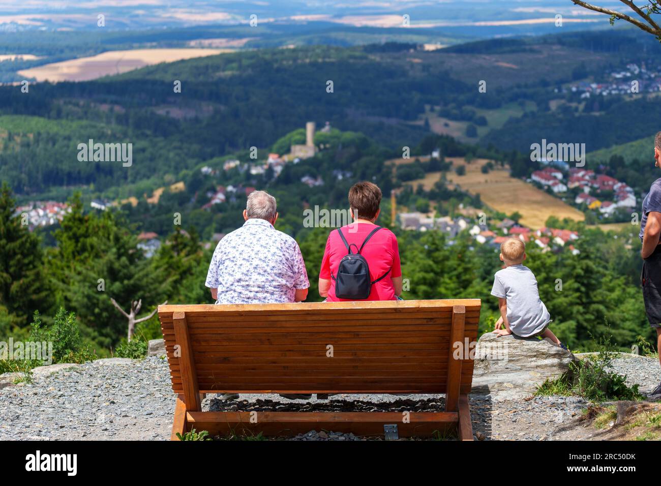 Schmitten, Germany. 12th July, 2023. Two people sit on a bench and look at the ruins of Reifenberg Castle. Numerous people visit the Feldberg plateau in fresh temperatures and gusty wind. Credit: Andreas Arnold/dpa/Alamy Live News Stock Photo