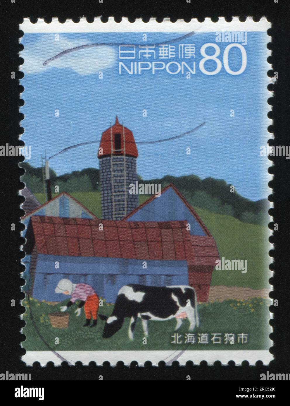 RUSSIA KALININGRAD, 22 APRIL 2016: stamp printed by Japan, shows a woman taking care of a caw and a kitchengarden near the country house, circa 2013 Stock Photo