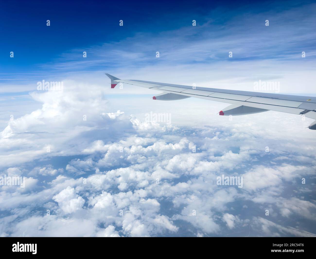 View of clouds and aircraft wing through window of British Airways Airbus A350, Europe Stock Photo
