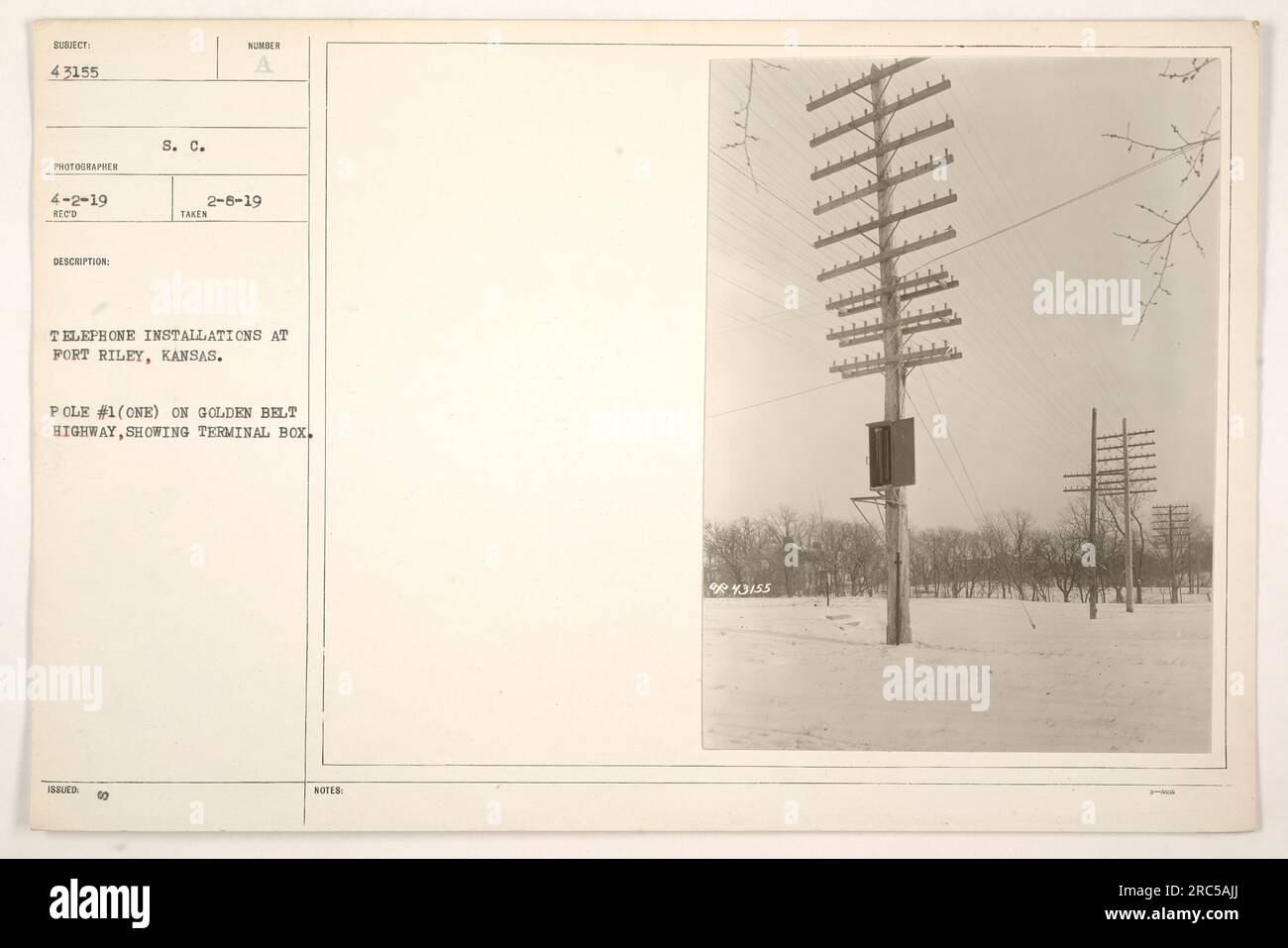 A photograph depicting a telephone installation at Fort Riley, Kansas during World War One. The image shows Pole #1 on the Golden Belt Highway with a terminal box. This image is labeled as 43155 in the S. C. Issuer collection. Stock Photo