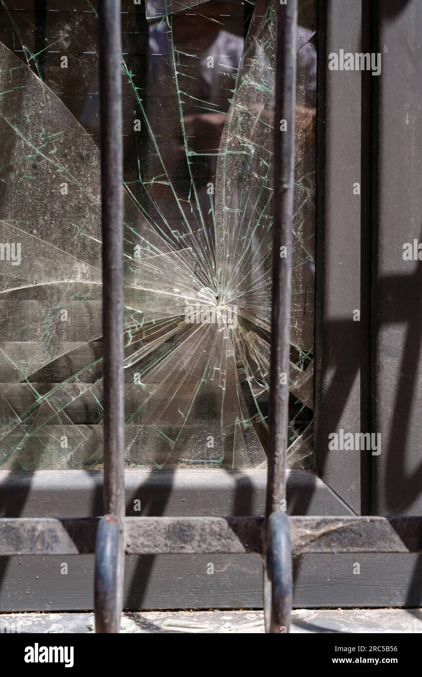 Shattered window glass with security bars close up Stock Photo