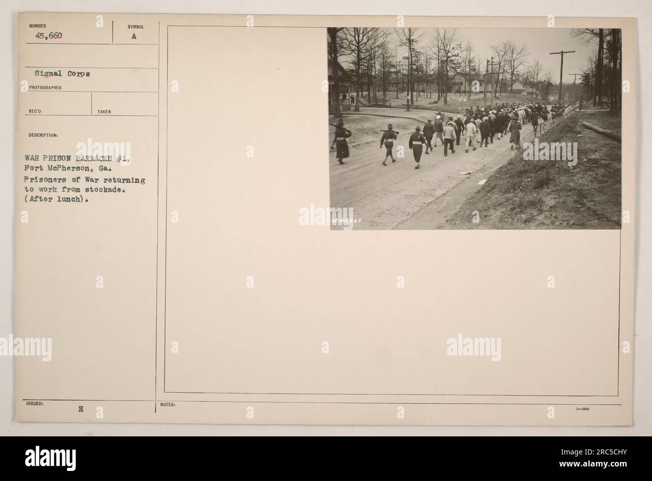 War prisoners at Fort McPherson in Georgia returning to work after lunch. The photograph shows a scene depicting prisoners of war outside the stockade. This image was taken by a photographer from the Signal Corps and the prisoners are labeled as number 45,660. Stock Photo
