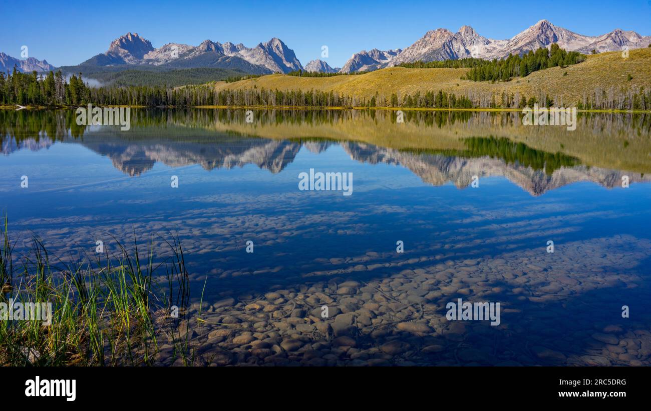 Sawtooth Mountains reflecting into Little Redfish Lake with clear, blue