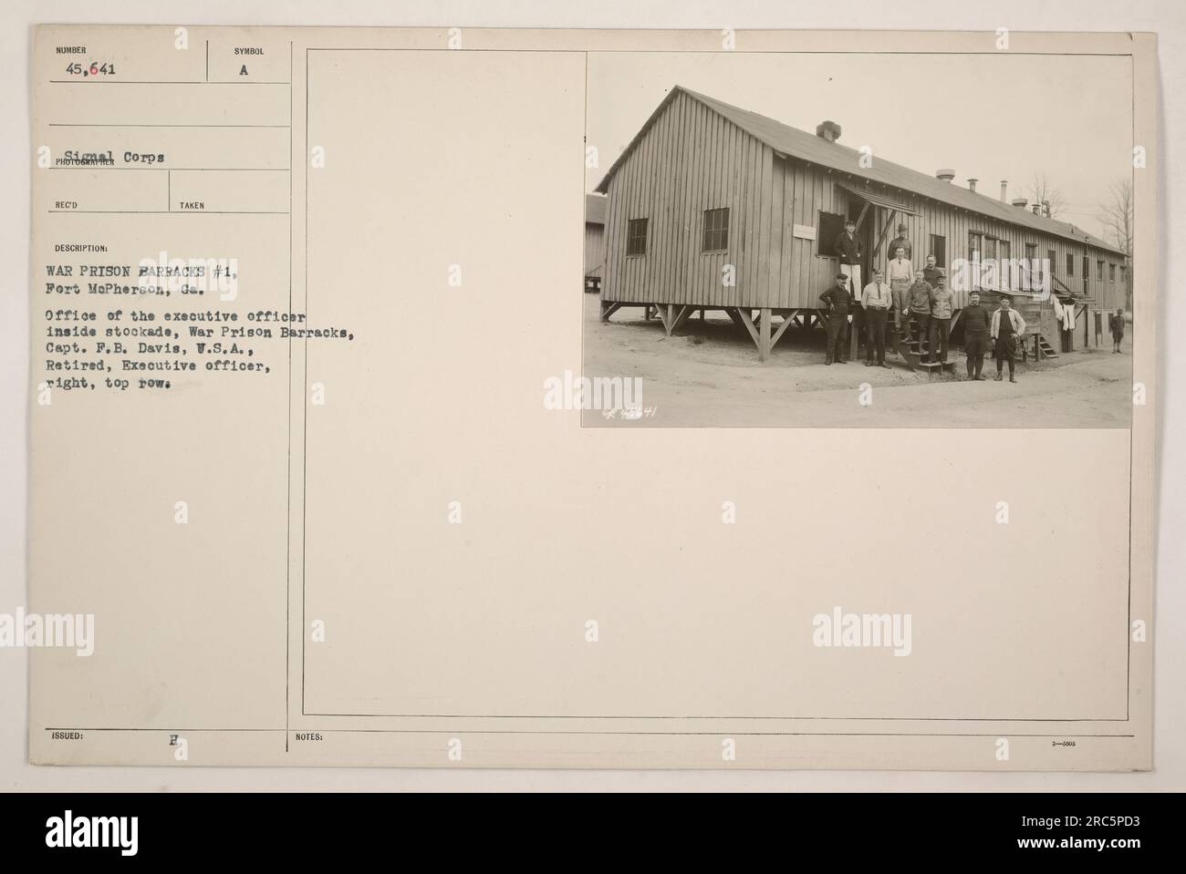 An image showing the office of the executive officer inside stockade at War Prison Barracks #1, located at Fort McPherson, Georgia during World War One. Captain F.B. Davis, a retired U.S.A. officer, is seen on the right in the top row of uniforms numbered 45,641 in the Signal Corps. The photograph was taken to document activities at the war prison barracks. Stock Photo