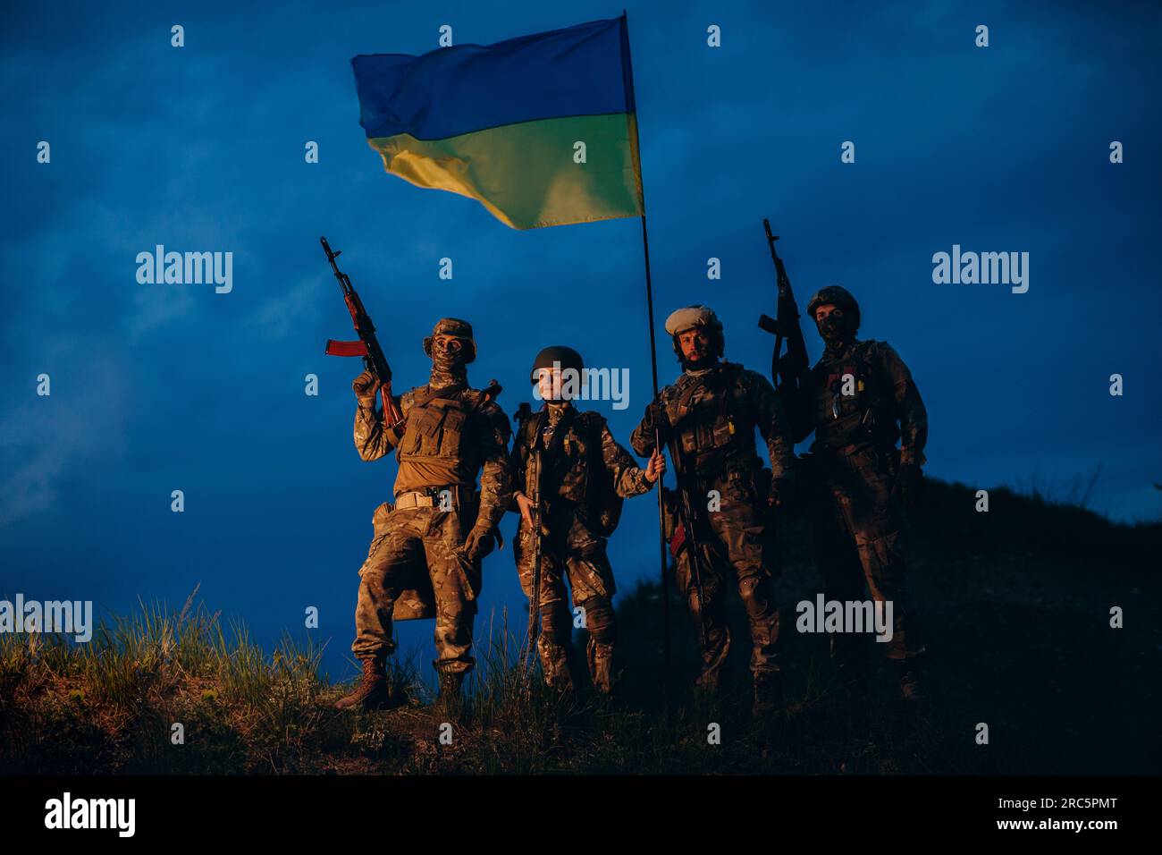 Portrait of Ukrainian warriors with a national flag in the evening ...