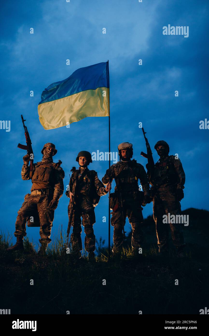 A group of armed Ukrainian soldiers posing for camera with a national ...