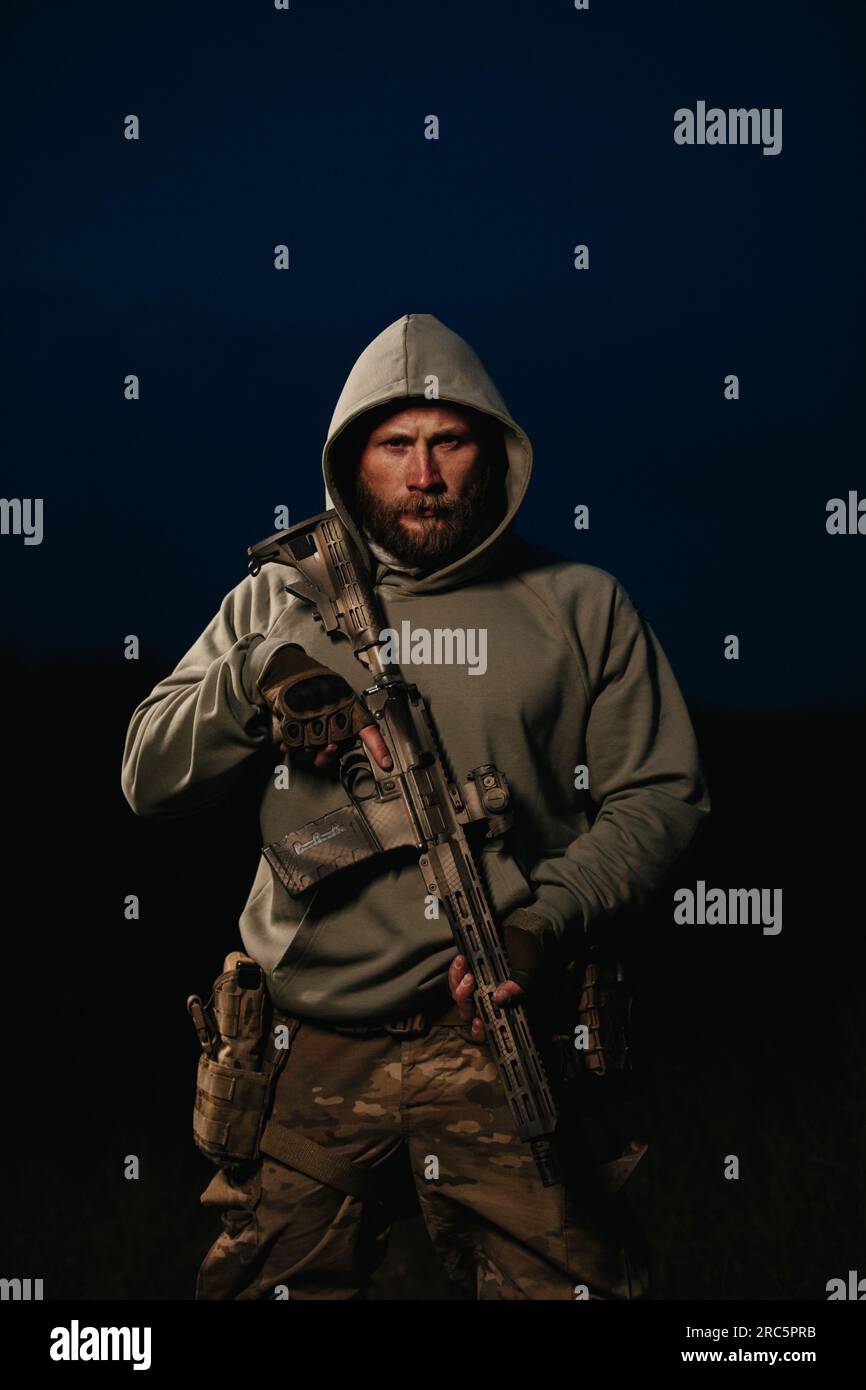 Portrait of an armed Ukrainian soldier wearing hoody and looking in the ...