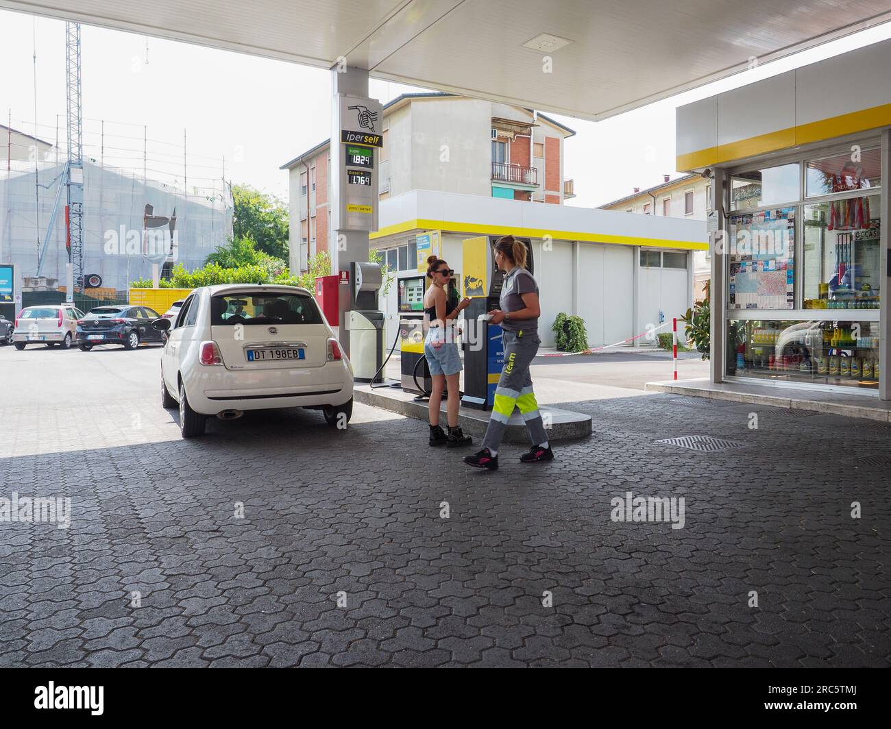 Cremona, Italy July 3 2023 gas station attendant woman taking