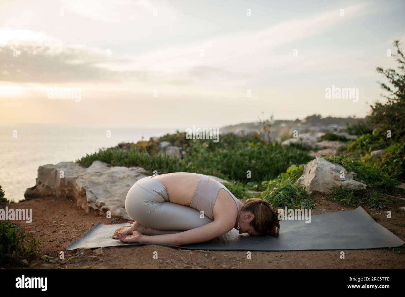 Young european lady in sportswear practices yoga, enjoys morning workout  outdoor Stock Photo - Alamy