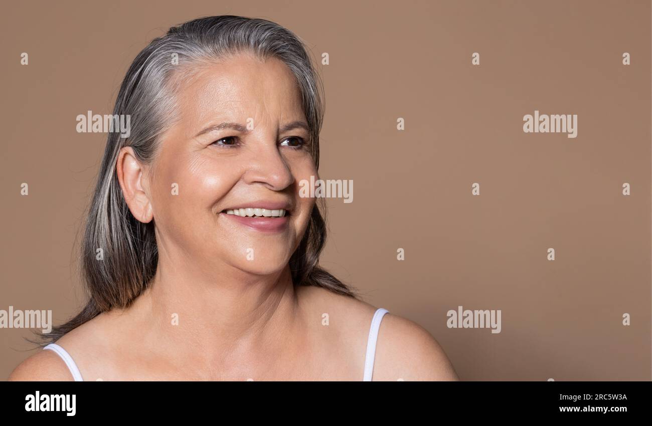 Happy elderly caucasian lady with gray hair, enjoys health care, anti-aging treatment, rejuvenation Stock Photo