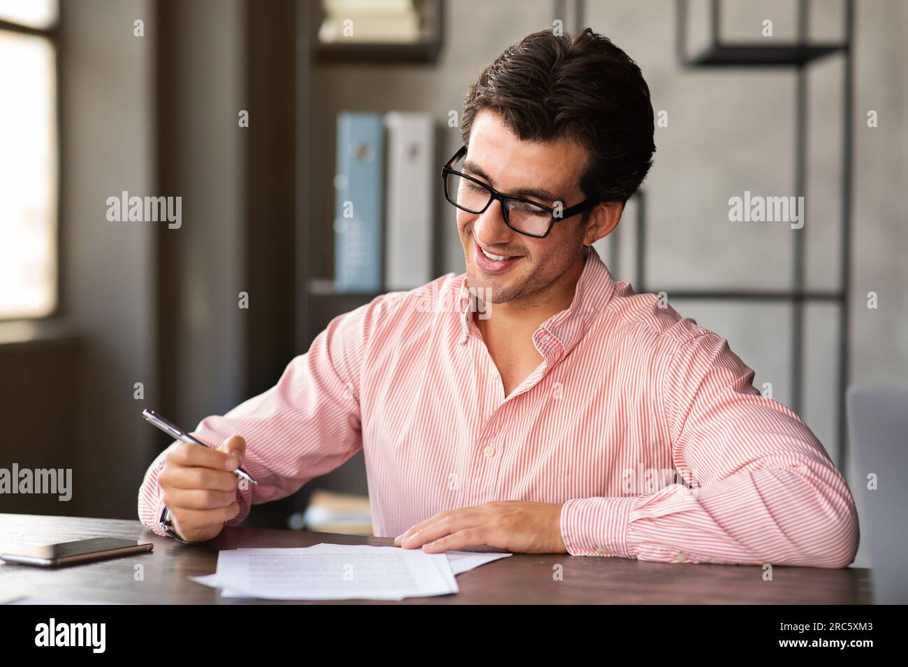 Handsome millennial european man attending job interview, filling papers Stock Photo