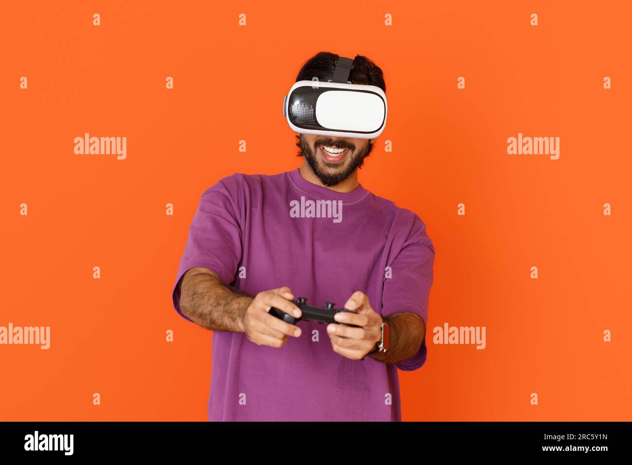 Middle eastern man playing video games, using VR glasses, joystick Stock Photo