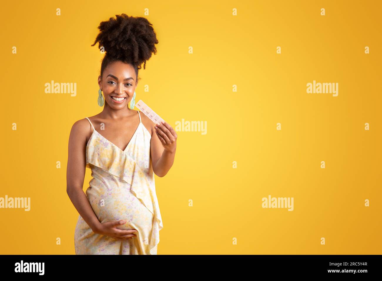 Pregnant Black Girl in Black Bra and Yellow Skirt Stock Photo - Alamy