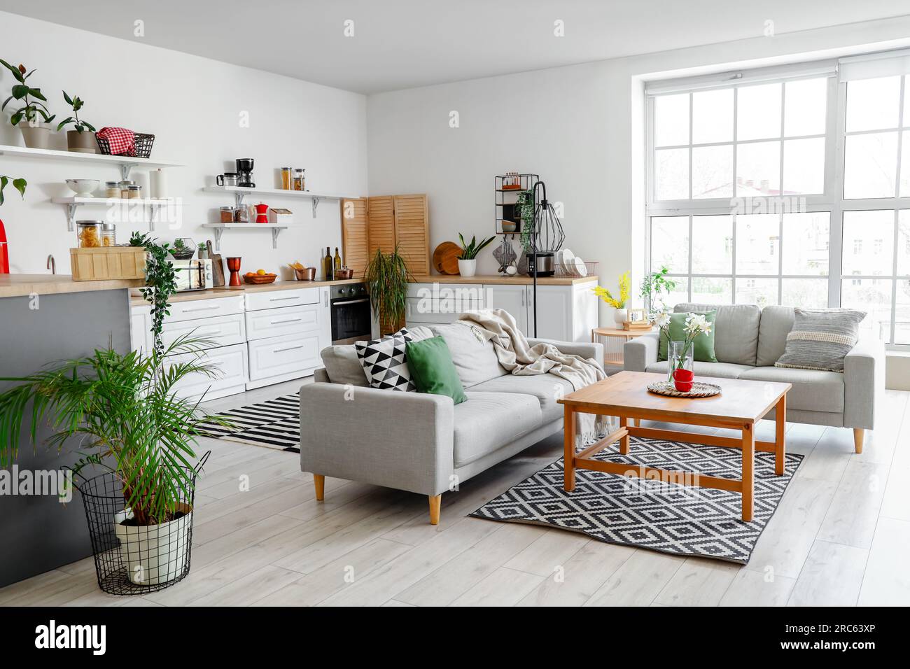 Interior of light kitchen with counters, shelves, table and sofas Stock ...