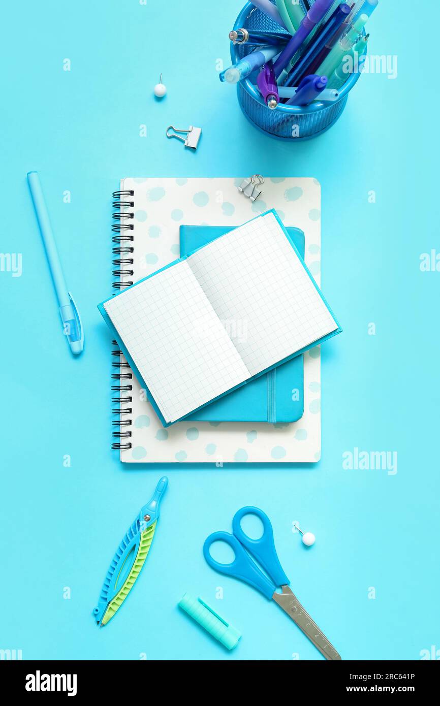 Composition with notebooks and different school stationery on blue background Stock Photo