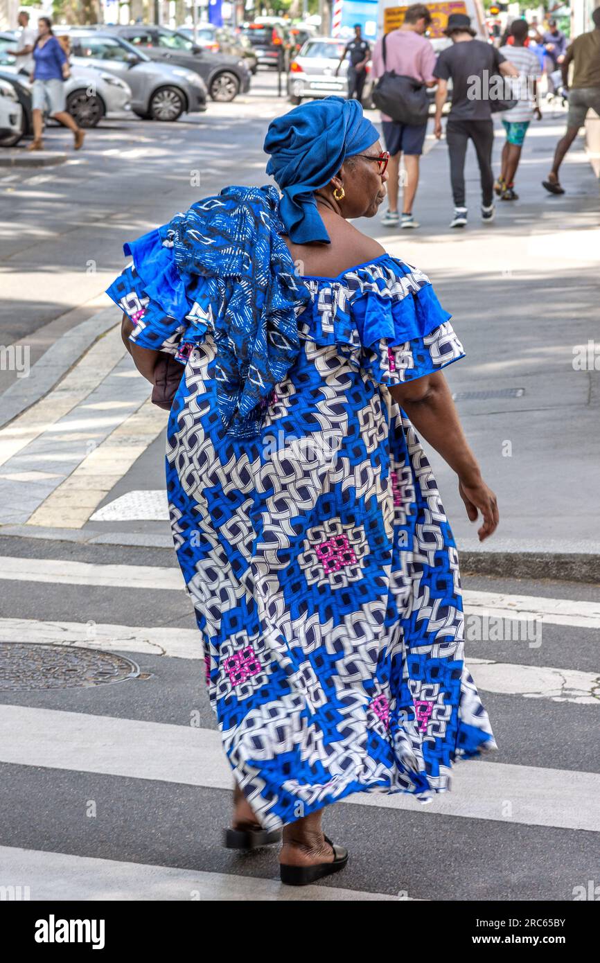 French-African woman crossing city center street on pedestrian crossing - Tours, Indre-et-Loire (37), France. Stock Photo